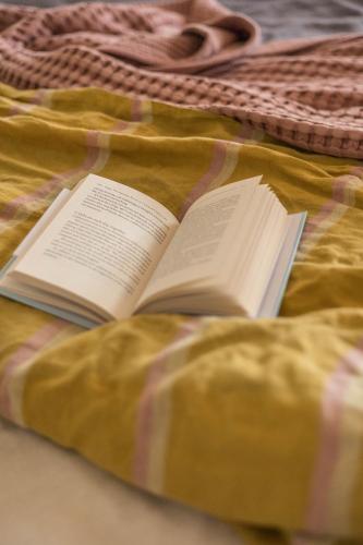 an open book on a blanket on a bed at Fern House in Wye River