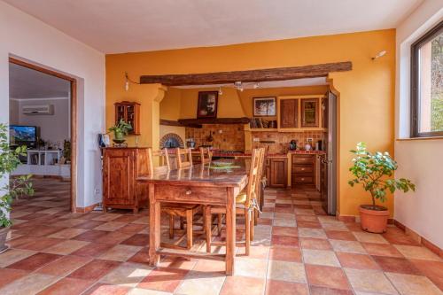 une cuisine avec une table et des chaises en bois dans l'établissement La Maison du Chapelier, à Fontaine-de-Vaucluse