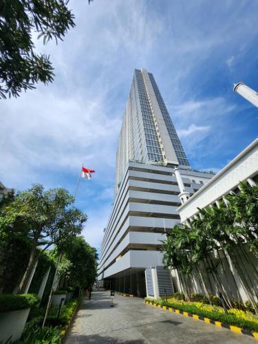 a tall building with a red flag in front of it at Menteng Park - Tower Diamond, 2 Bed Rooms, Private Lift in Jakarta