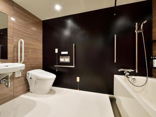 a bathroom with a white toilet and a sink at Hotel Elcient Osaka Umeda in Osaka