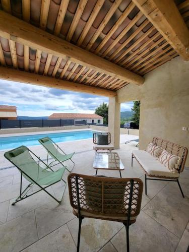 un patio avec des chaises et une piscine dans l'établissement La Grange des Joumillons, à Saint-Saturnin-lès-Apt