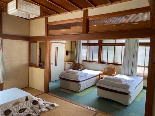 - une chambre avec 2 lits dans l'établissement ソルトハウス, à Imabari