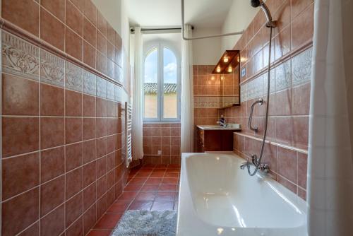 uma casa de banho com uma banheira e um lavatório em Mas Côté Cour em Maubec