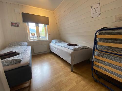 リューカンにあるSentralt hus i Rjukanのベッド2台と窓が備わる小さな客室です。