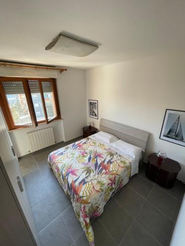 a bedroom with a bed with a colorful blanket at Ville et Mer - tra città e mare in Porto Recanati