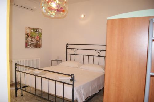 Schlafzimmer mit einem Bett und einem Kronleuchter in der Unterkunft Appartamento La Pineta in Marina di Cecina