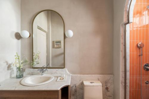 a bathroom with a sink and a mirror and a toilet at Manuscript - Jhilwara Haveli in Udaipur