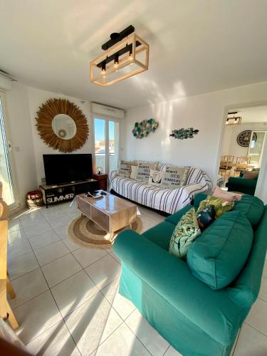 un salon avec un canapé bleu et une table dans l'établissement Opale beach, Merlimont,100msea,2 bedrooms, parking, à Merlimont