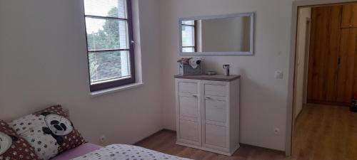 1 dormitorio con tocador blanco y espejo en Perla27, en Říčky