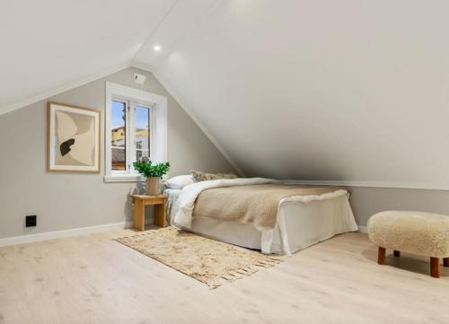 a white bedroom with a bed and a window at Charming Town House in Centrum in Bergen