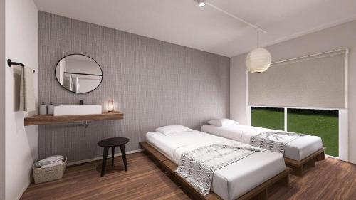 een slaapkamer met 2 bedden en een spiegel bij 与那国島ホテル むんぶステイ 比川浜 in Sonai