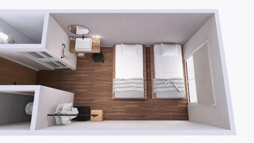 mały pokój z 2 łóżkami i białymi ręcznikami w obiekcie 与那国島ホテル むんぶステイ 比川浜 w mieście Sonai
