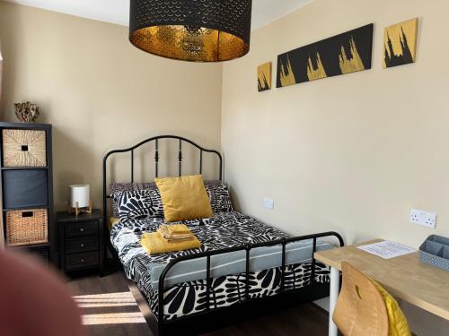 a bedroom with a bed with black and yellow pillows at Rectory Cottage in Croydon