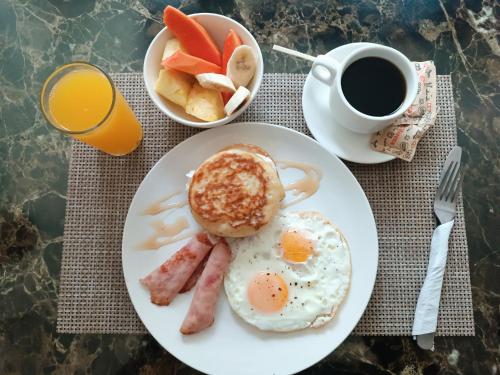 un plato con huevos y tocino y una taza de café en HOTEL BLUE COSTA Panama, en Panamá