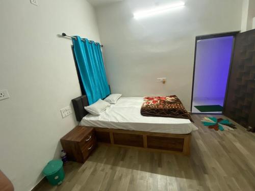 Habitación pequeña con cama y ventana en Marina Home Stay en Bodh Gaya