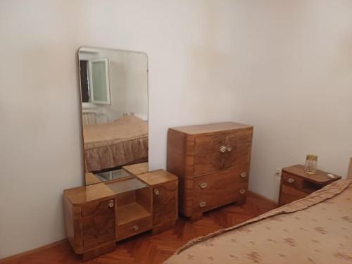 a bedroom with a mirror and a dresser and a bed at Kamnita hiša in Koper