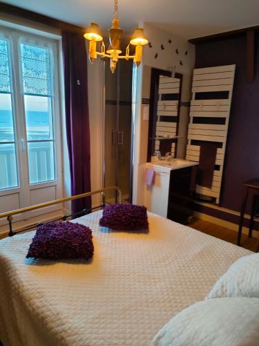 - une chambre avec un grand lit orné de fleurs violettes dans l'établissement La bicheraie, à Arromanches-les-Bains