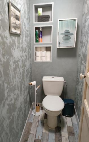 une salle de bain avec des toilettes blanches dans une chambre dans l'établissement La bicheraie, à Arromanches-les-Bains