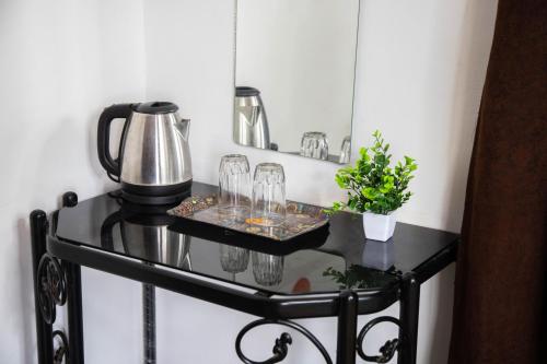 a glass table with glasses and a tea kettle on it at Beyond the Reef - NestinGoa Homestays in Arambol