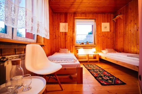 um quarto com duas camas e uma cadeira em Dom na Szlaku em Wisla