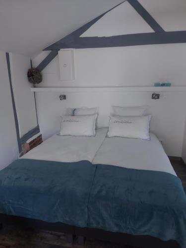ein Schlafzimmer mit einem großen Bett mit zwei Kissen in der Unterkunft Gîte, Le Séchoir à Lin demeure de charme 