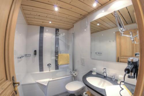 a bathroom with a sink and a toilet and a mirror at Hotel Grüner Baum in Würzburg