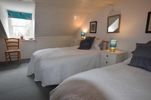 sypialnia z 2 łóżkami, krzesłem i oknem w obiekcie Rural Farmhouse on Kintyre, West Coast hidden gem w mieście Kildalloig