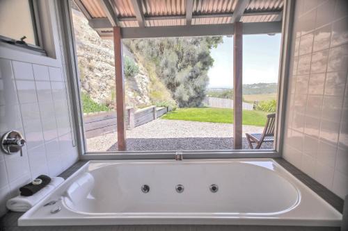a bath tub in a bathroom with a window at Anchors Port Campbell in Port Campbell