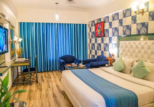 1 dormitorio con 1 cama grande y cortina azul en Hotel Dreamland Inn, en Zirakpur