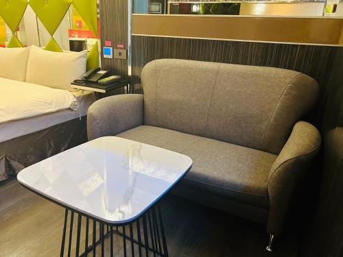 a chair and a table in a room with a bed at 響悅汽車旅館 in Xinwu