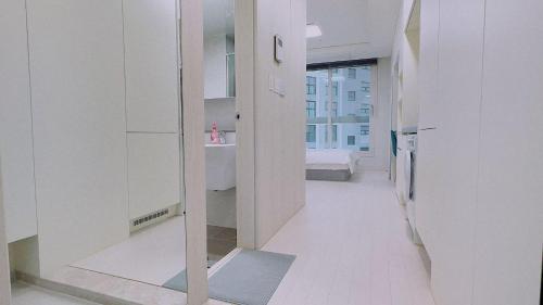 a room with a hallway with a mirror and a bed at The Time hotel Incheon Airport in Incheon