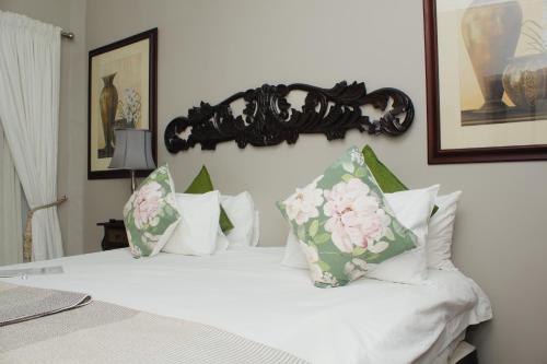 a bedroom with a bed with white sheets and pillows at Oaklands inn and Conference Centre in Johannesburg