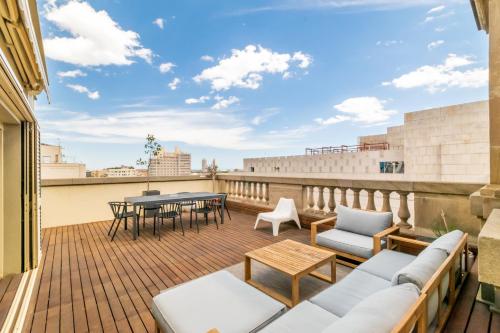a balcony with furniture and a table on a building at Unique Rentals - Placa Catalunya Central Apartments in Barcelona
