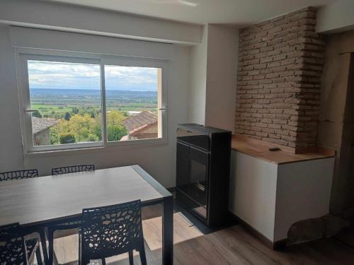 une cuisine avec une table et une grande fenêtre dans l'établissement Maison au calme pour 8 personnes à 2 pas du château d Anjou, à Anjou