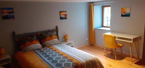 1 dormitorio con cama, escritorio y silla amarilla en Ô JOLi BUGEY en Saint-Rambert-en-Bugey