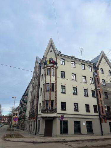 un grand bâtiment blanc au coin d'une rue dans l'établissement Beautiful Designer Apartment in Riga center, à Riga
