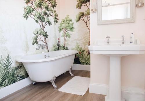 a bathtub and sink in a bathroom with plants on the wall at Southsea, Portsmouth - Two Bedroom Apartment - Newly Refurbished Throughout - Treetop Sea Views in Portsmouth