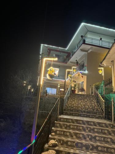 a building with stairs leading up to it at night at Paradise Inn by HBR in Dharmsala