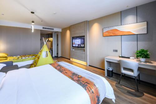 sypialnia z dużym łóżkiem i biurkiem oraz kuchnia w obiekcie Shanshui S Hotel w Guangzhou