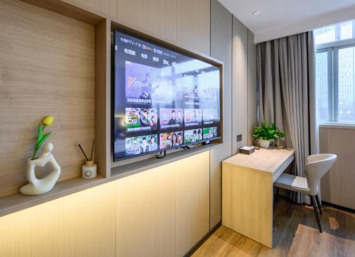 a living room with a large flat screen tv on a wall at Shanshui S Hotel in Guangzhou