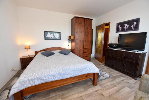 een slaapkamer met een bed en een flatscreen-tv bij Haus "Luv und Lee" Appartement LEE15 in Döse