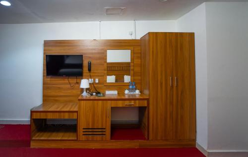 um quarto com uma secretária, uma televisão e um armário em AL KARNAK HOTEL - BRANCH em Dubai