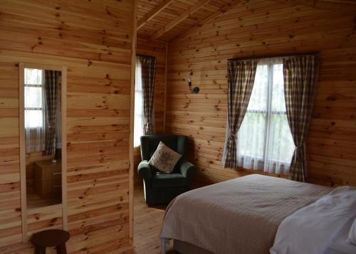 um quarto com uma cama e uma cadeira num camarote em Agva Himalaya Motel em Agva