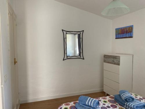 een slaapkamer met een bed en een spiegel aan de muur bij Apartamento Bellavista in Cala'n Bosch