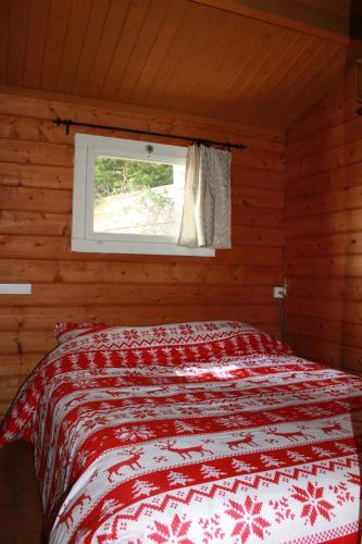 a bedroom with a bed in a room with a window at chalet au cœur des bois in La Salvetat