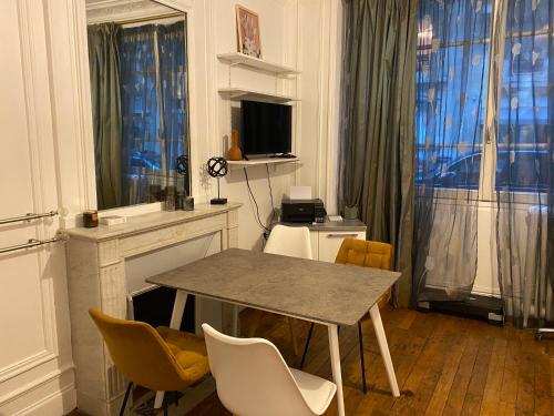 une salle à manger avec une table et des chaises et une fenêtre dans l'établissement Appartement Passy Tour Eiffel, à Paris