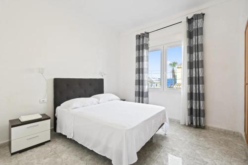 Un dormitorio blanco con una cama grande y una ventana en Casa Las Calas, en Torrevieja