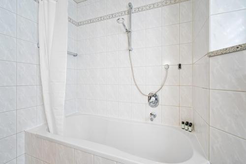 a white bathroom with a shower with a white tub at HomeTonight - Komfortables Haus für bis zu 9 Monteure oder Urlauber in Marktredwitz