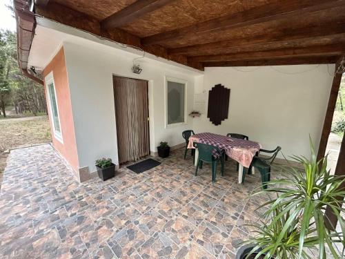 a patio with a table and chairs in a house at Šumska kuća Juga Kovačević in Bela Crkva