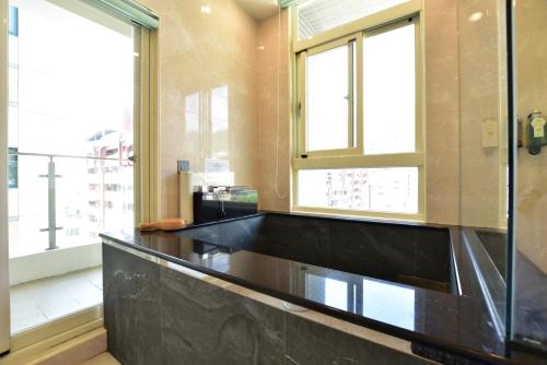 a kitchen with a black counter top and two windows at Muen Yuan Dong Hot Spring Hotel in Jiaoxi